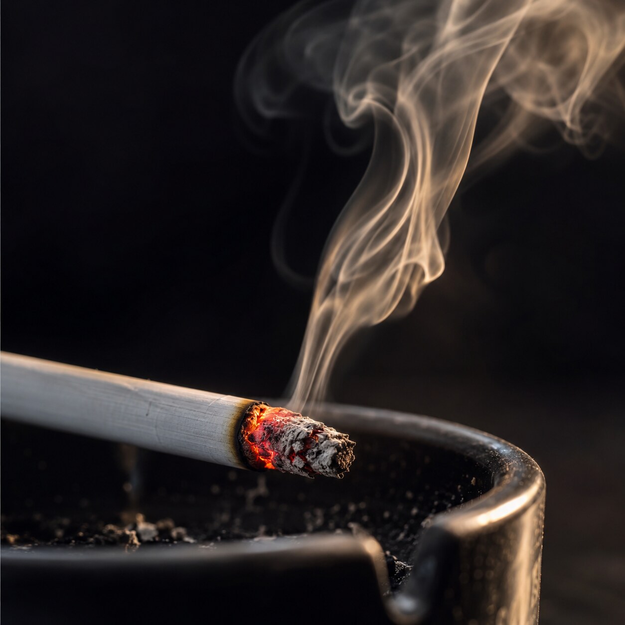 Close-up of a lit cigarette with smoke curling upward, representing chronic smoking's documented association with elevated neutrophil counts