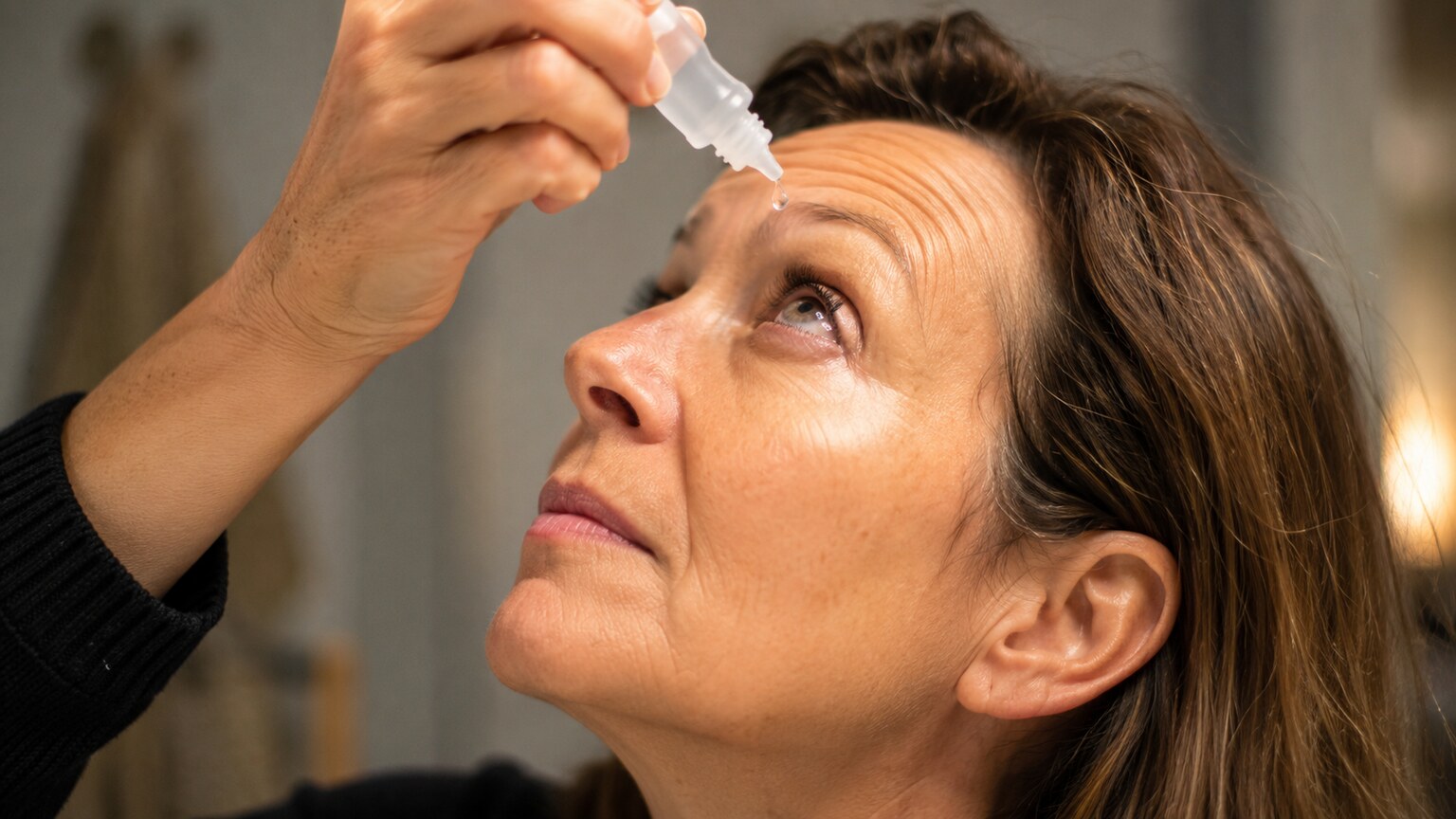 Close-up of a person applying lubricating eye drops to relieve persistent dry, irritated eyes
