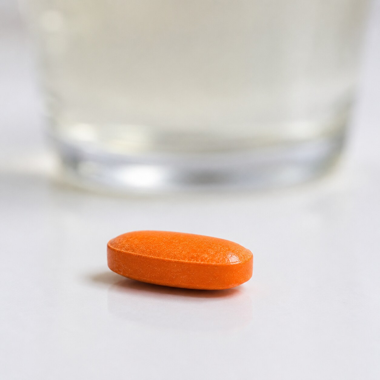 Close-up macro photograph of an orange phenazopyridine tablet known for turning urine bright orange